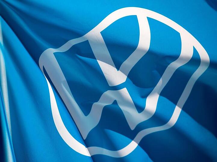 Eine Fahne mit dem VW-Logo weht im Fahrzeugwerk von Volkswagen in Zwickau.