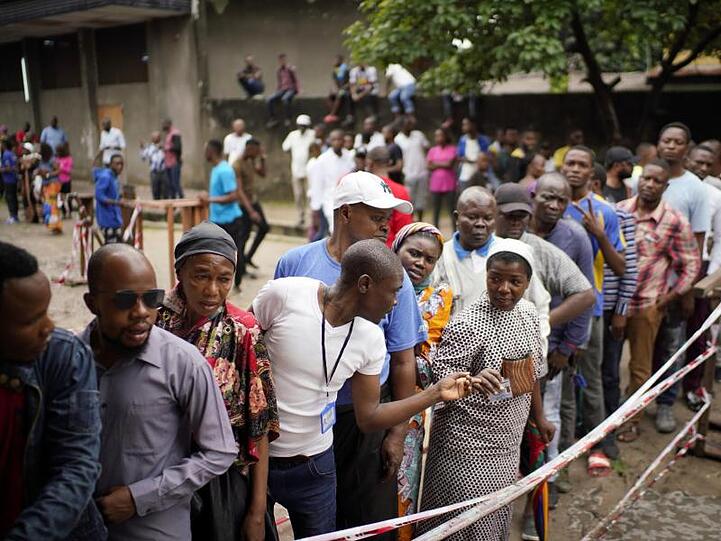 Wähler warten vor einem Wahllokal in Kinshasa auf die Abgabe ihres Stimmzettels.