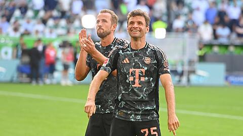 Thomas Müller (vorne) hat gut Lachen nach dem Erfolg in Wolfsburg, Teamkollege Harry Kane kann ob dessen Lauf und der Rekorde des Ur-Bayern einfach nur noch applaudieren.