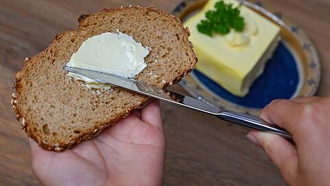Ein Mädchen streicht Butter auf eine Scheibe Brot. Pro Jahr konsumiert jeder Deutsche etwa, 5,6 Kilogramm Butter.Foto: Patrick Pleul/dpa
