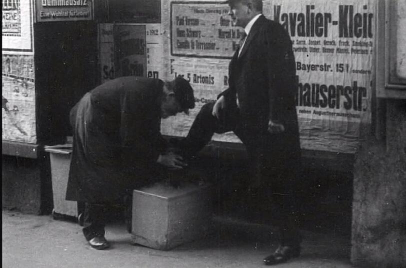 Früher war alles besser? Ein alter Schuhputzer 1914 bei seiner Arbeit am Rathaus am Marienplatz.
