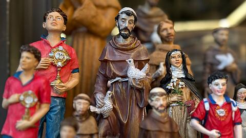Figuren des alten und des neuen Heiligen stehen in Souvenirshops nebeneinander. (Archivbild)