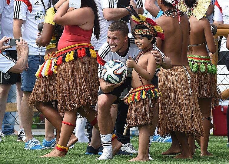 Tuchfühlung: Lukas Podolski mit Einheimischen nach dem Montagstraining in Santo André, Bahia. Foto: Marcus Brandt