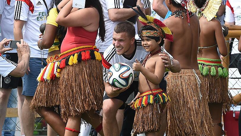 Tuchfühlung: Lukas Podolski mit Einheimischen nach dem Montagstraining in Santo André, Bahia. Foto: Marcus Brandt Tuchfühlung: Lukas Podolski mit Einheimischen nach dem Montagstraining in Santo André, Bahia. Foto: Marcus Brandt