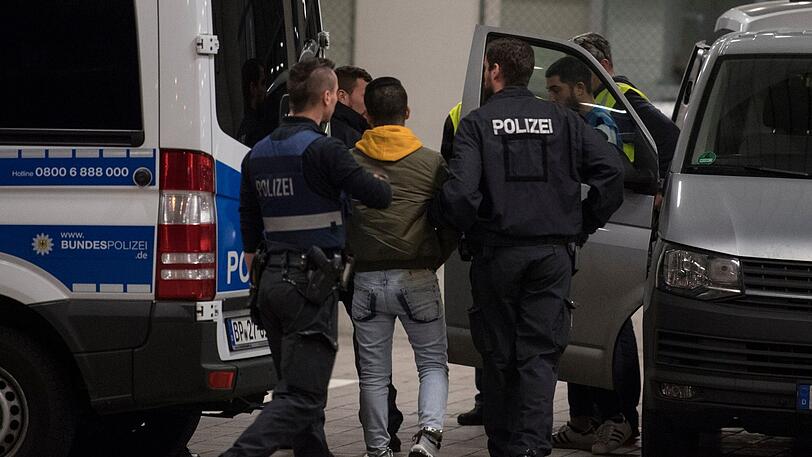 Hand- und Fußfesseln trägt dieser Mann aus Afghanistan, den Polizisten zur Abschiebung bringen.