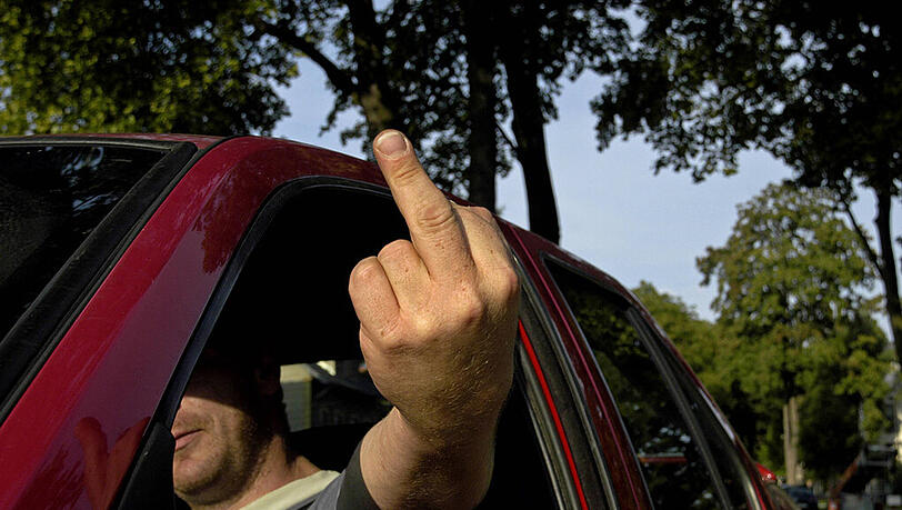 Wütender Autofahrer zeigt Stinkefinger (Symbolbild). Wütender Autofahrer zeigt Stinkefinger (Symbolbild).
