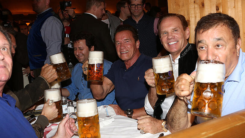 Erst eine kühle Maß, danach Dirigieren auf der Bühne: Die Bilder vom Schwarzenegger-Besuch im Schützen-Festzelt.