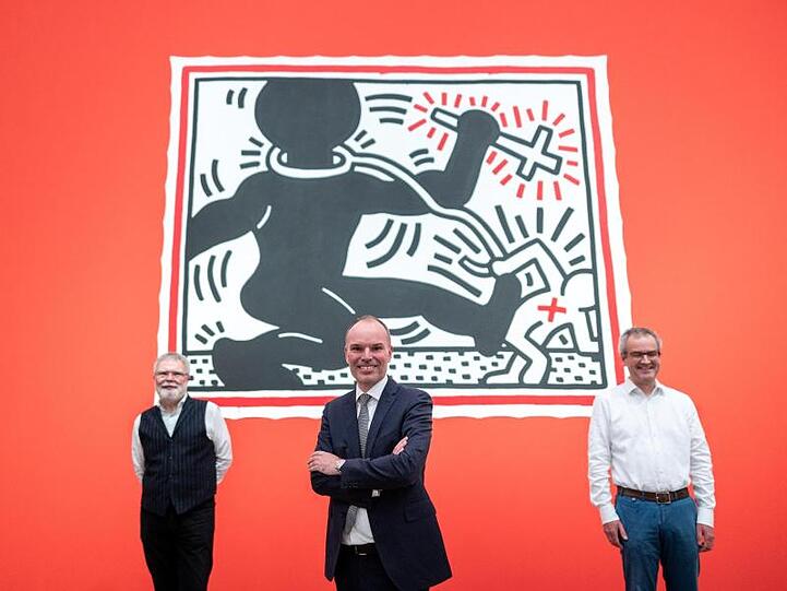 Rene Grohnert (l-r), Leiter Deutsches Plakat Museum, Peter Gorschlüter, Direktor Museum Folkwang, und Hans-Jürgen Lechtreck, stellvertrender Direktor Museum Folkwang, vor einem Bild von Keith Haring.