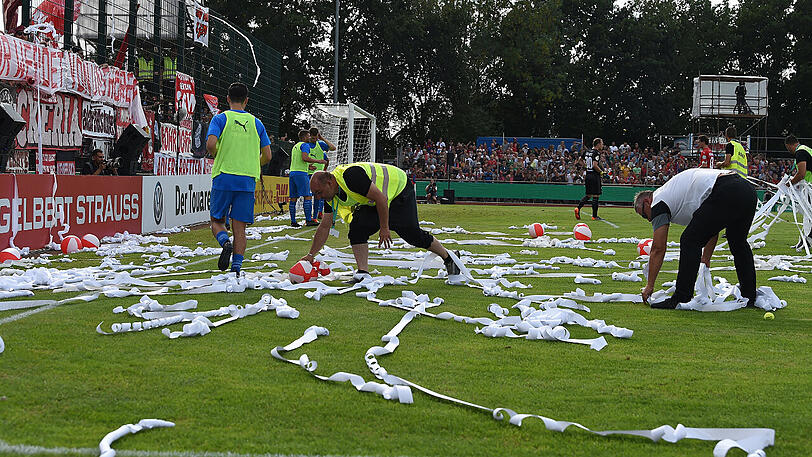 "Fans" des FC Bayern sorgen im Kehdinger Stadion für eine fünfminütige Unterbrechung, indem sie Plastikbälle und Toilettenpapierrollen auf den Rasen werfen.