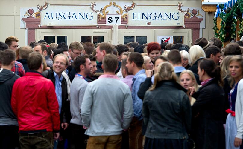Trotz Sauwetter und Regen warten bereits viele Wiesngänger auf den Wiesnanstich. Der Kampf um den Platz im Bierzelt beginnt schon am frühen Morgen. Die ersten Bilder.