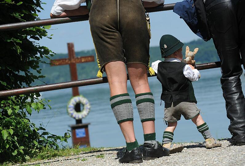 Ein Bub betrachtet das Gedenkkreuz an Ludwigs Todesstelle.