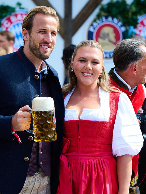 Bayerns Torj&auml;ger Harry Kane genie&szlig;t mit Gattin Katie im Dirndl das M&uuml;nchner Wiesn-Flair &ndash; auf dem Platz jagt er Rekorde, daneben tr&auml;umt er leise vom Ballon d&rsquo;Or.