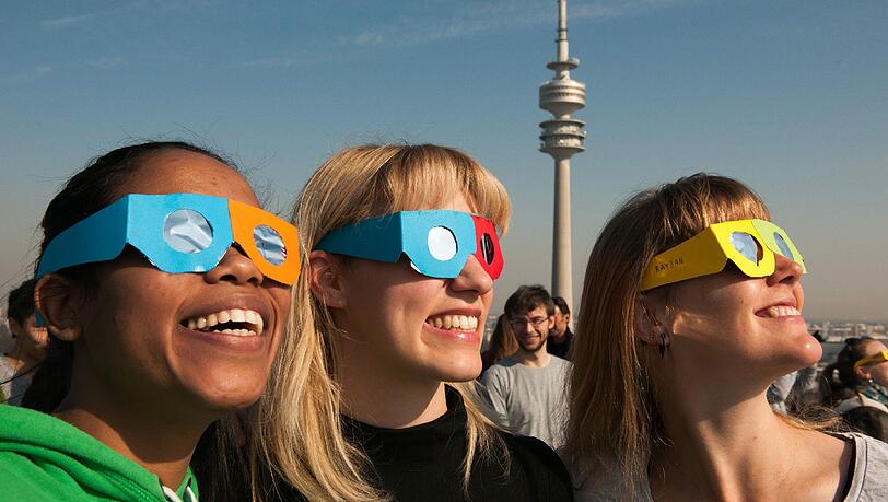 Diese drei Damen scheinen die Sonnenfinsternis sichtlich zu genießen.