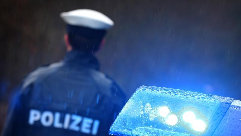 Ein Polizist steht vor einem Streifenwagen dessen Blaulicht aktiviert ist. Foto: Karl-Josef Hildenbrand/dpa/Archiv
