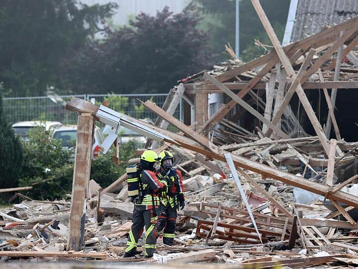 Feuerwehrleute stehen in den Trümmern einer Halle. Foto: Mario Obeser/dpa