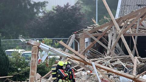 Feuerwehrleute stehen in den Trümmern einer Halle. Foto: Mario Obeser/dpa