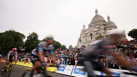 Die Radprofis treten vor der Basilika Sacre Coeur im Stadtteil Montmartre in die Pedale.