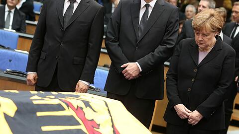 Bundeskanzlerin Angela Merkel (CDU) verneigt sich vor dem Sarg.