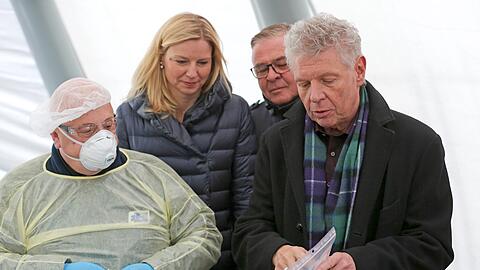 Gesundheitsreferentin Stephanie Jacobs (parteilos) mit OB Dieter Reiter (rechts) und Peter Aicher, Geschäftsführer von Aicher Ambulanz (2. von rechts) mit einem medizinischen Fachangestellten in Schutzmontur, der im Zelt an der Bayernkaserne im "Drive-in-Test" Abstriche bei Coronavirus-Verdachtsfällen nimmt.