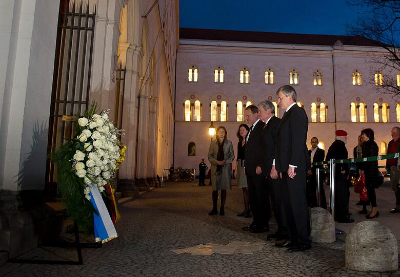 Bundespraesident Joachim Gauck (2.v.r.), der Praesident der Ludwig-Maximilians-Universitaet (LMU), Bernd Huber (r.) und der bayerische Wissenschaftsminister Wolfgang Heubisch (FDP, 3.v.l.) stehen in Muenchen vor dem Bodendenkmal fuer die Weisse Rose auf dem Geschwister-Scholl-Platz,vor dem Hauptgebaeude der LMU.