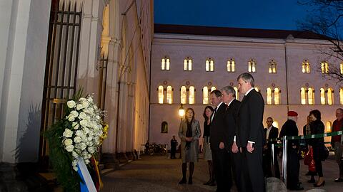 Bundespraesident Joachim Gauck (2.v.r.), der Praesident der Ludwig-Maximilians-Universitaet (LMU), Bernd Huber (r.) und der bayerische Wissenschaftsminister Wolfgang Heubisch (FDP, 3.v.l.) stehen in Muenchen vor dem Bodendenkmal fuer die Weisse Rose auf dem Geschwister-Scholl-Platz,vor dem Hauptgebaeude der LMU.