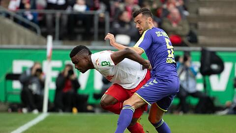 Der Kölner Jhon Cordoba (l.) und der Freiburger Manuel Gulde kämpfen um den Ball. Foto: Federico Gambarini/dpa