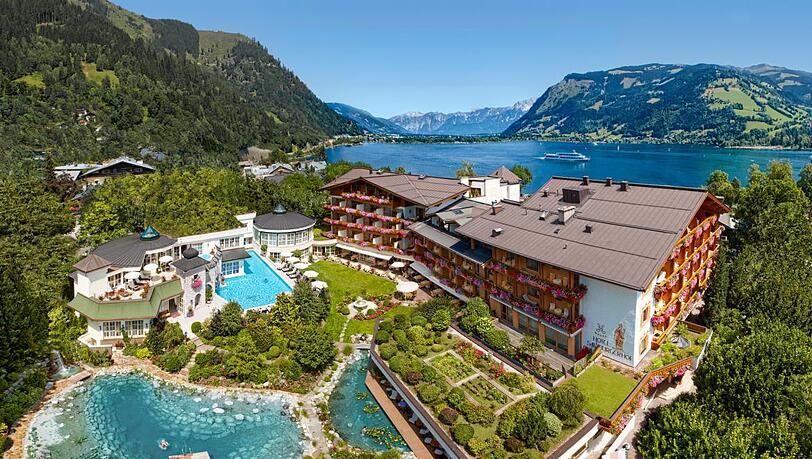 Vor dem Salzburgerhof sind Badeteich und Au&szlig;enpool zu sehen. Dahinter liegt der Zeller See.
