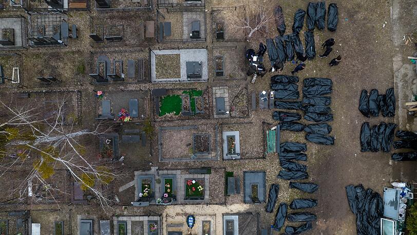 Polizisten arbeiten auf einem Friedhof in Kiew an der Identifizierung von Toten. Polizisten arbeiten auf einem Friedhof in Kiew an der Identifizierung von Toten.