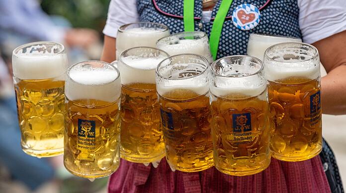 Eine Bedienung trägt acht Maß Bier.