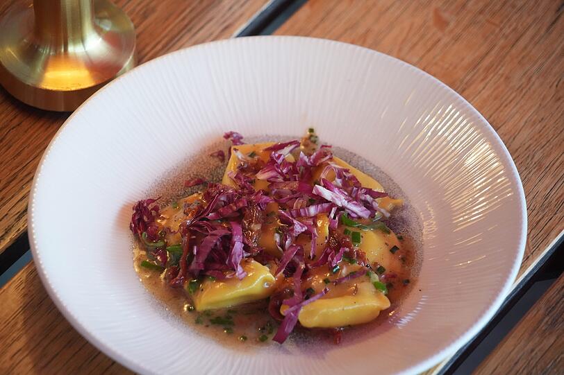 Zweiter Gang: Pfifferlings-Ravioli, getrocknete Tomaten, Kräuternage, Radicchio.
