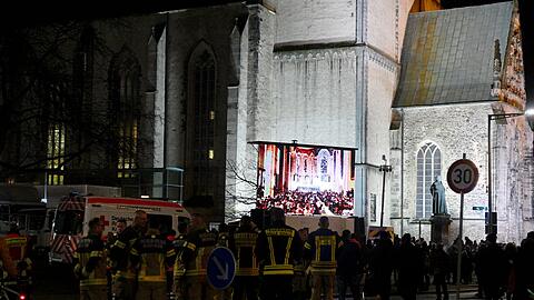 Vor der Kirche versammelten sich Menschen, um die Gedenkveranstaltung zu verfolgen.