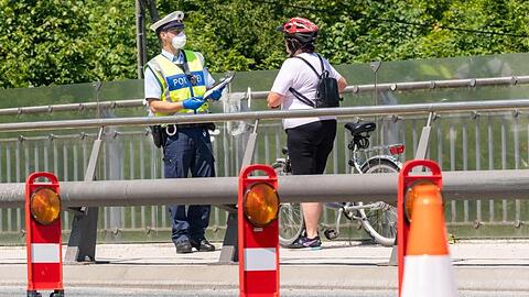 Ein deutscher Bundespolizist kontrolliert im Mai eine Fahrradfahrerin am bayerischen Grenzübergang Freilassing zwischen Deutschland und Österreich.