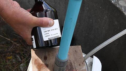 An einer Messtelle wird eine Grundwasserprobe entnommen, die auf Nitrat überprüft wird. Foto: picture alliance / Uli Deck/dpa/Symbolbild