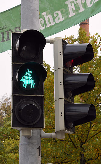 Die Bremer Stadtmusikanten sind als Grünes Signal an einer Ampel an einem der Eingänge zum Freimarkt in Bremen zu sehen.
