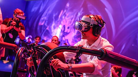 Ein wilder Ritt bei der Gamescom 2024: Hendrik W&uuml;st auf einem "Drachen", genauer gesagt mit virtueller Brille auf einem schwankenden Gestell.