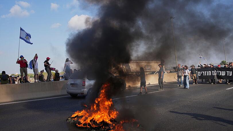 Israelische Demonstranten blockieren eine Straße bei einem Protest. Israelische Demonstranten blockieren eine Straße bei einem Protest.