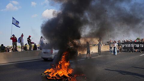 Israelische Demonstranten blockieren eine Straße bei einem Protest.