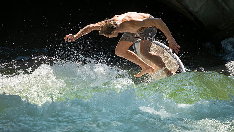 Ein Surfer auf der Eisbachwelle im Englischen Garten in München. Ein Surfer auf der Eisbachwelle im Englischen Garten in München.
