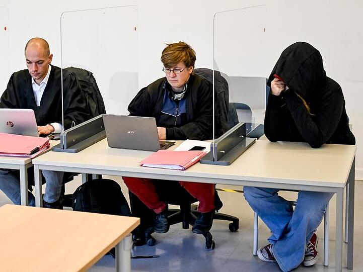 Die Angeklagten (l und r) und ihre Verteidiger, Alexander Kienzle (2.v.l.) und Britta Eder, sitzen im Prozess um einen damaligen Münchner Polizisten, der privat beim G20-Gipfel in Hamburg war, und eine Frau die fast zeitgleich Bierdosen von der Brücke Breite Straße auf dort eingesetzte Polizisten geworfen haben, im Gerichtssaal. Foto: Axel Heimken/dpa/POOL/dpa
