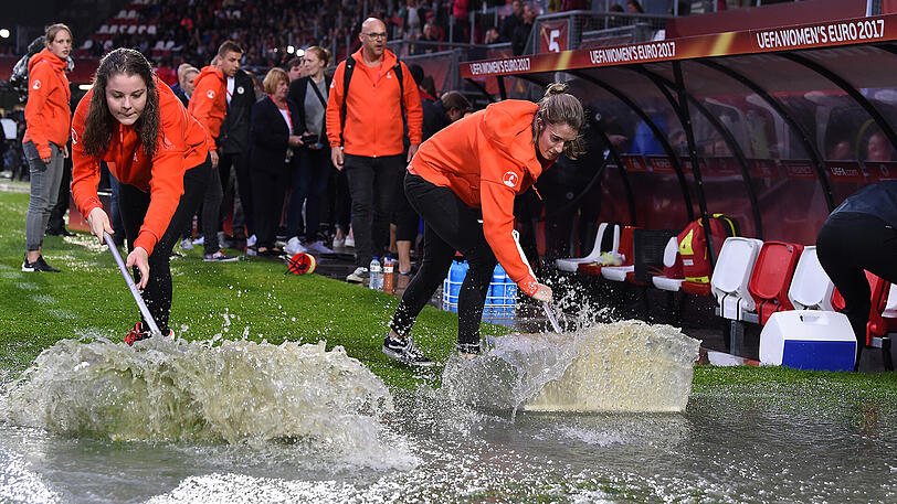 Freiwillige versuchen, dem Wasser im Stadion Heer zu werden. Vergebens.