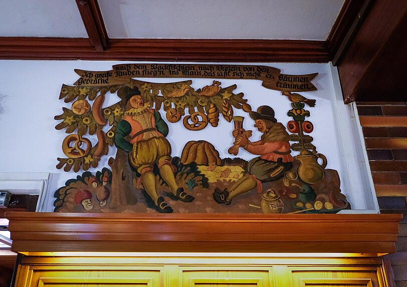 Die urigen Holzfresken des Kunstmalers W. Erlacher zeigen Märchenmotive wie "Das Schlaraffenland" und "Tischlein deck dich".