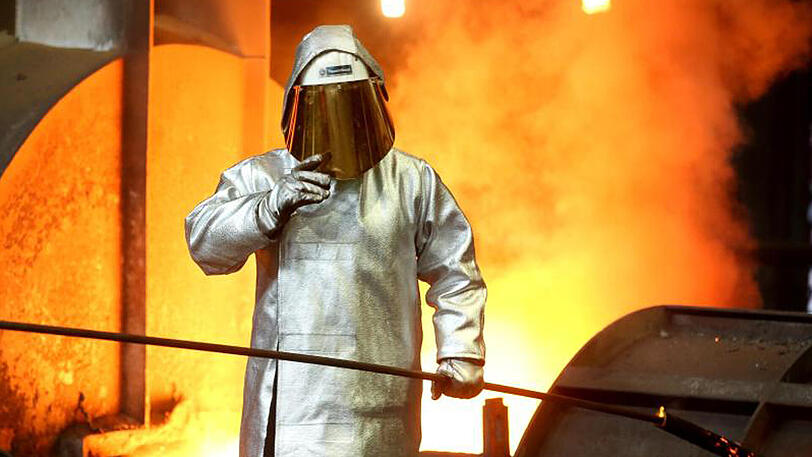 Ein Stahlarbeiter prüft am Hochofen 8 bei ThyssenKrupp in Duisburg die Stahlqualität nach dem Abstich.