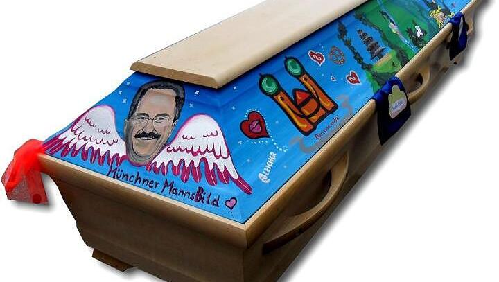 Diesen Sarg gestaltete Chris Bleicher im Auftrag der St&auml;dtischen Bestattung. Oberb&uuml;rgermeister Christian Ude als Engel mit Fl&uuml;geln, r&uuml;ckw&auml;rtslaufende Uhren und das M&uuml;nchner Kindl.