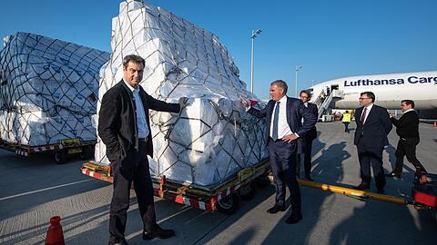 Bayerns Ministerpräsident Markus Söder (CSU, l.) nimmt im April 2020 im Beisein von Carsten Spohr (2.v.l.), Vorstandsvorsitzender der Deutschen Lufthansa AG, in München eine Lieferung von Schutzmasken aus Shanghai in Empfang.