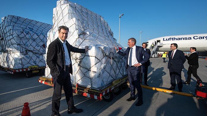 Bayerns Ministerpräsident Markus Söder (CSU, l.) nimmt im April 2020 im Beisein von Carsten Spohr (2.v.l.), Vorstandsvorsitzender der Deutschen Lufthansa AG, in München eine Lieferung von Schutzmasken aus Shanghai in Empfang.