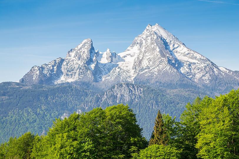 Dominant und ehrfürchtig ragt der Watzmann als zentraler Bergstock in den Berchtesgadener Alpen. Der charakteristische Berg ist mit seinen 2.713 Metern der zweithöchste Berg Deutschlands - nach der Zugspitze. Unverwechselbar ist die beeindruckende Felsformation am Gipfel. Wegen der Haupt- und Nebengipfel wird die Formation oft als "Familie Watzmann" bezeichnet. Dominant und ehrfürchtig ragt der Watzmann als zentraler Bergstock in den Berchtesgadener Alpen. Der charakteristische Berg ist mit seinen 2.713 Metern der zweithöchste Berg Deutschlands - nach der Zugspitze. Unverwechselbar ist die beeindruckende Felsformation am Gipfel. Wegen der Haupt- und Nebengipfel wird die Formation oft als "Familie Watzmann" bezeichnet.