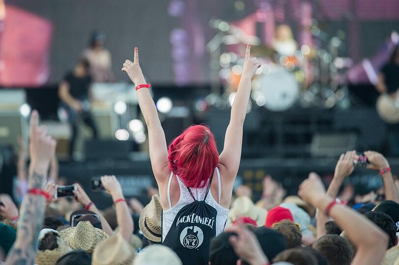 Eine Besucherin des "Rock im Park" feiert am 05.06.2015 vor der Hauptbühne.