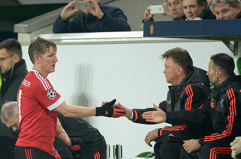 Bastian Schweinsteiger von Manchester United klatscht nach seiner Auswechslung im Spiel gegen den VfL Wolfsburg mit Trainer Louis van Gaal ab.