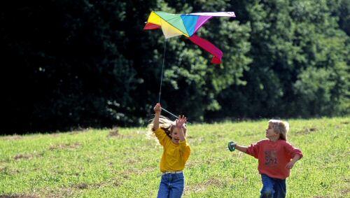 Unbeschwert: Kinder lassen einen Drachen steigen Unbeschwert: Kinder lassen einen Drachen steigen