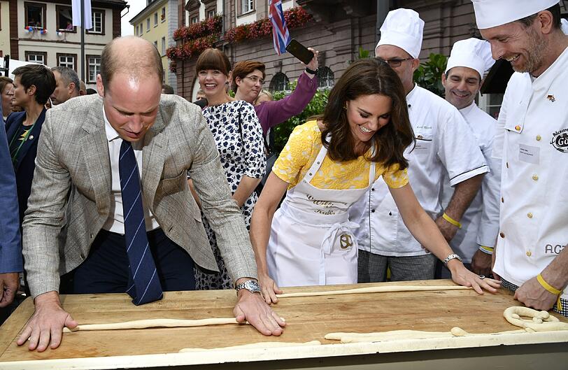 Der britische Prinz William und seine Frau Herzogin Kate formen auf dem Marktplatz in Heidelberg Brezeln